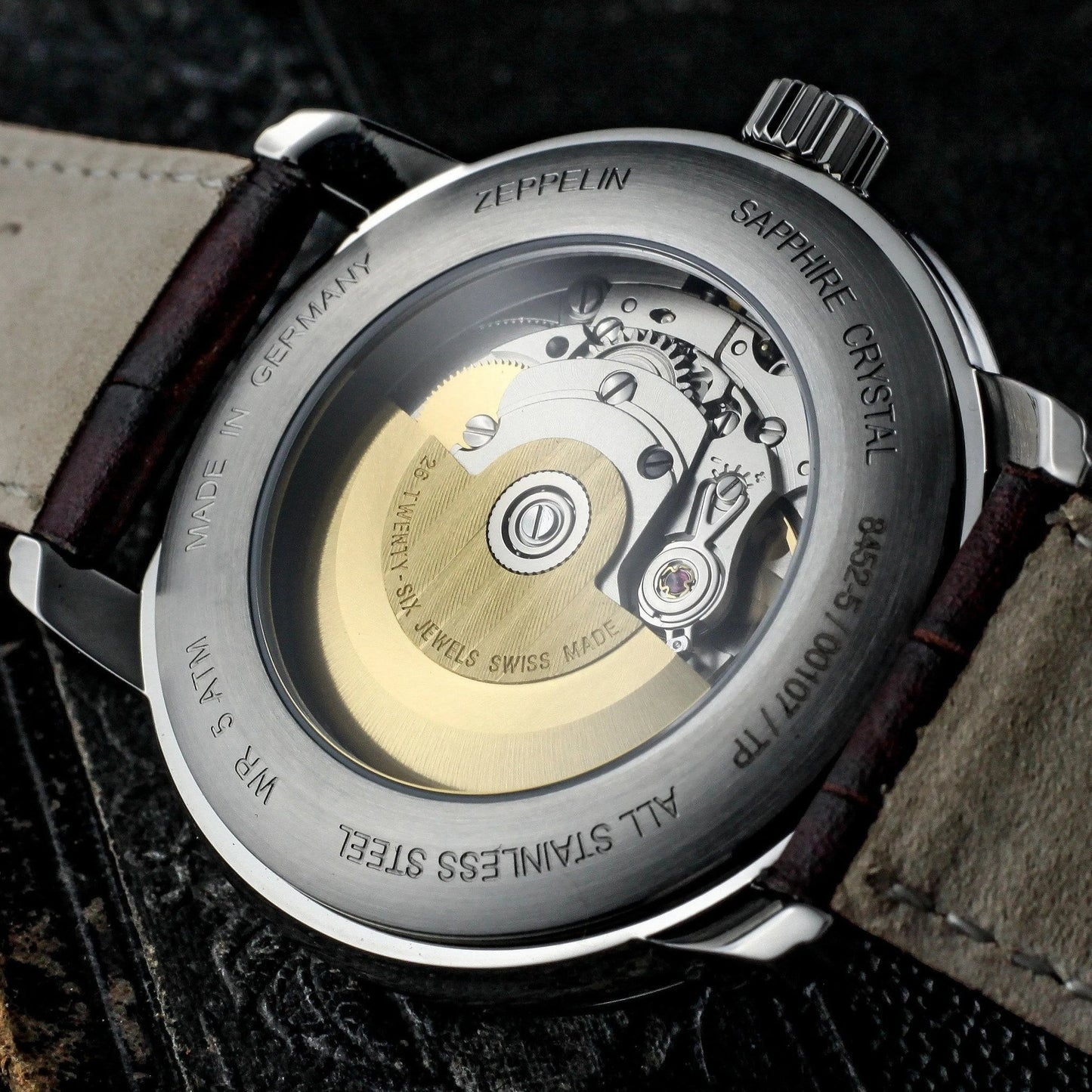 Rückseite der Zeppelin Herren Automatik-Armbanduhr mit Glasboden. Sichtbares Schweizer Uhrwerk mit goldfarbenem Rotor und Edelstahlgehäuse.