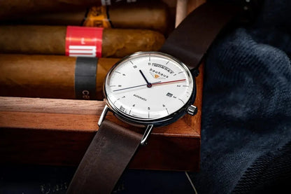 Bendixen-Braun Bauhaus automatic men's watch with white dial, stainless steel case, leather strap, and day/date display.