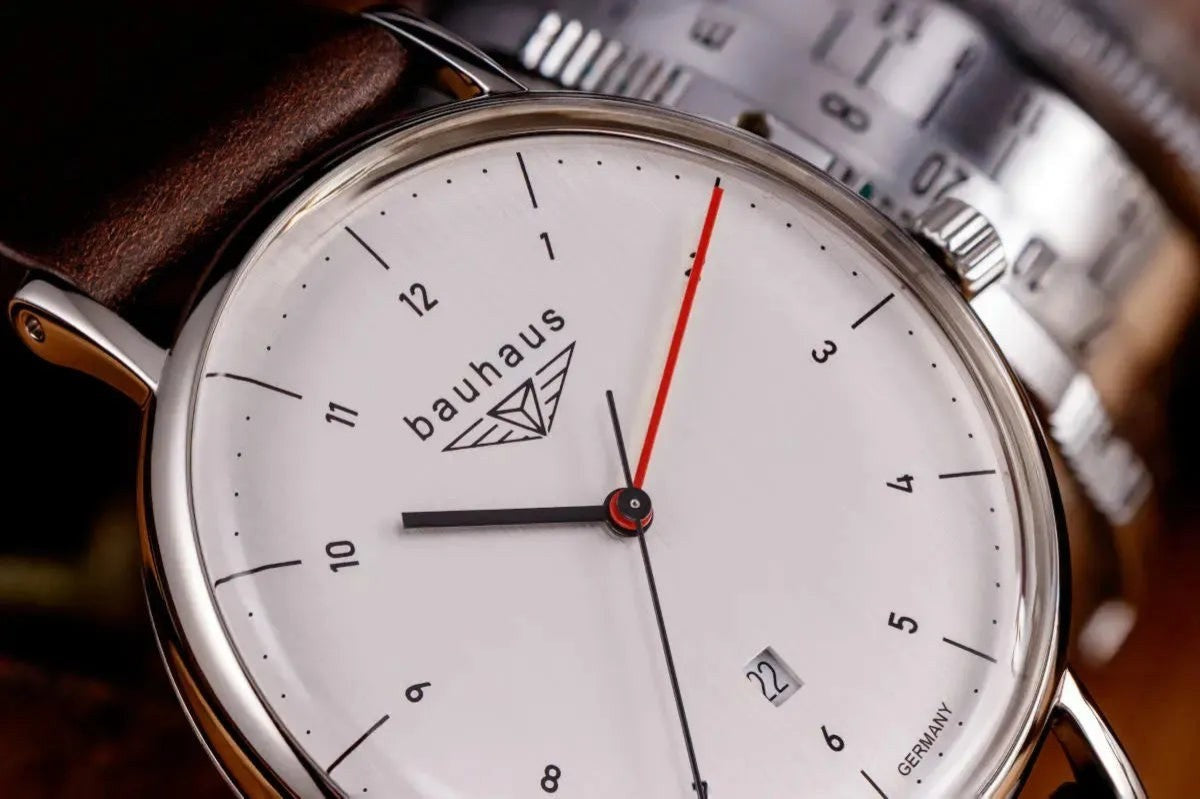 Bendixen-Braun Bauhaus men's watch with white dial, date window, red seconds hand, and brown leather strap.
